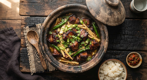 Smoked pork with bamboo shoot and green chillies in a rustic clay pot